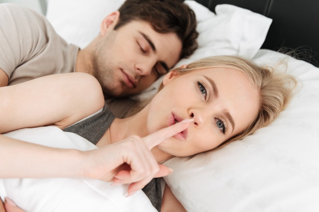 A couple sleeping in their bed.