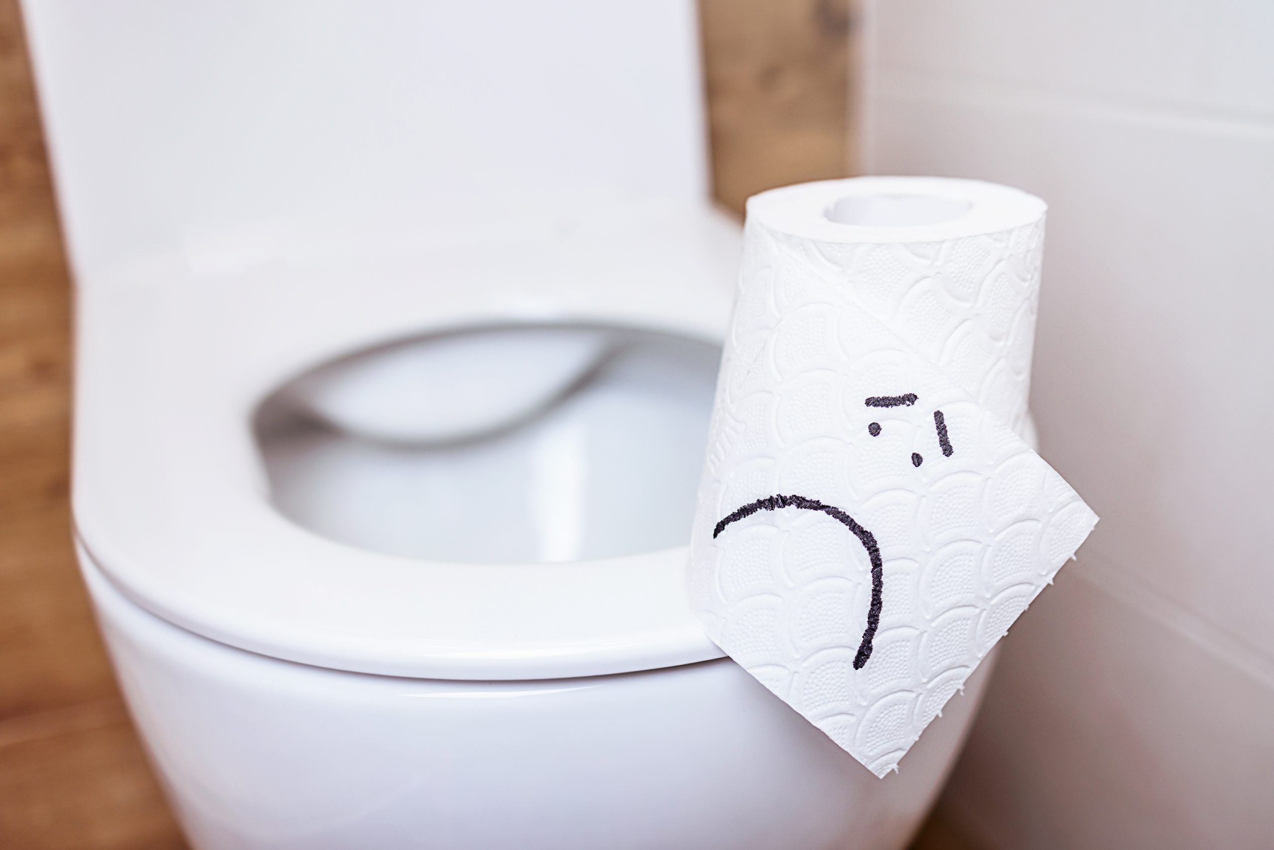 a toilet paper with a sad face drawn on it