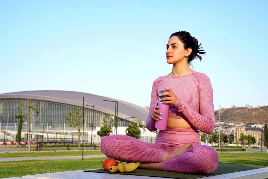 A woman sitting in a yoga mat.