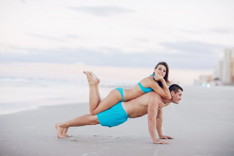 a person and person with six pack on a beach doing exercise