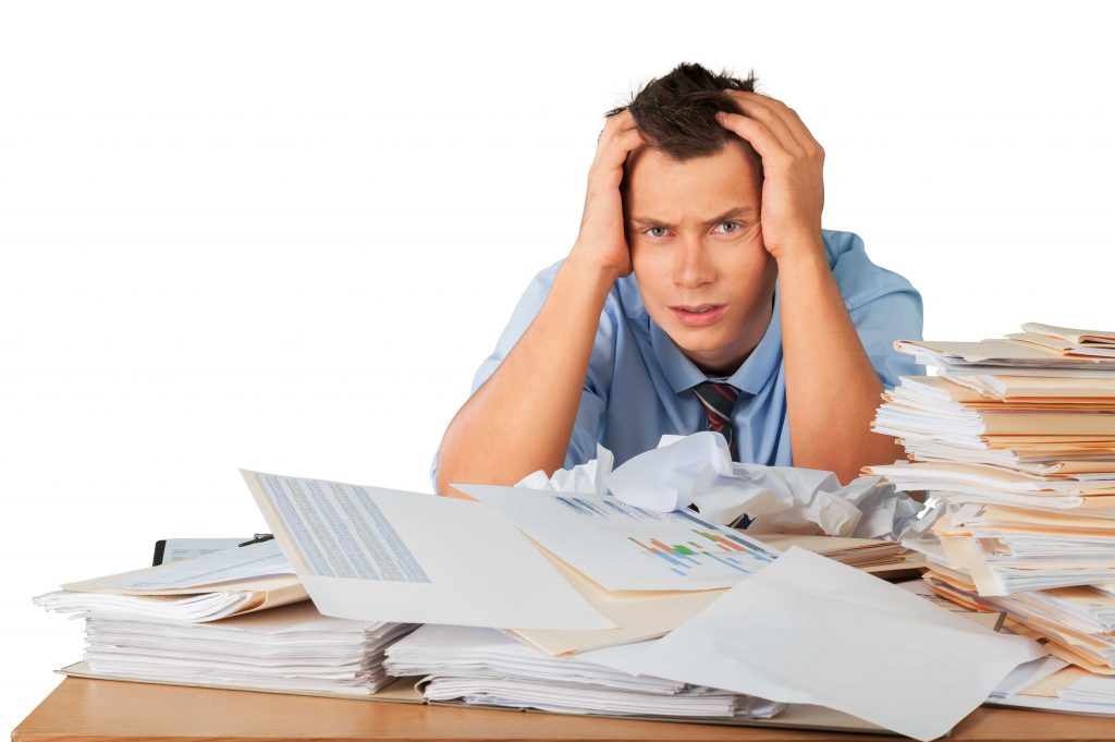 stress can cause hair loss..man tired at work with lots of paper work