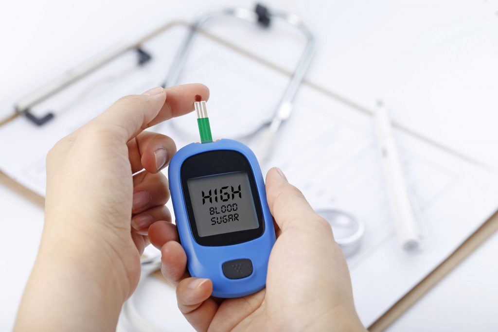 a person holding a blood sugar meter