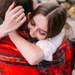 man and woman hugging inside a blanket