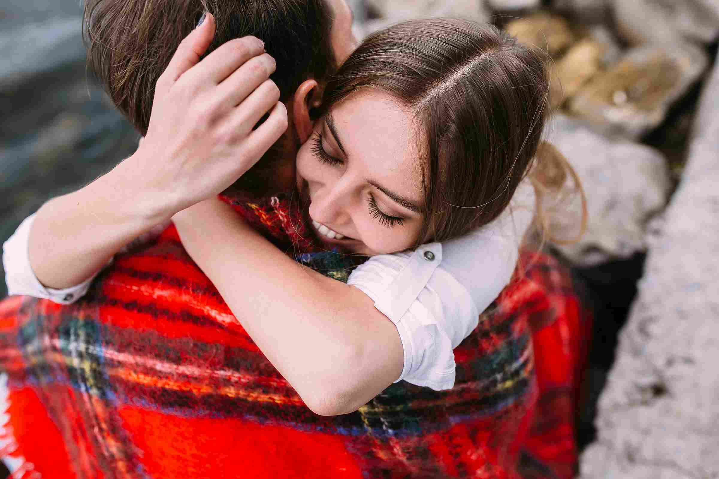 man and woman hugging inside a blanket