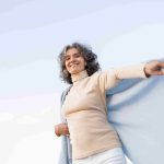 Older woman going through climacteric period having fun at beach