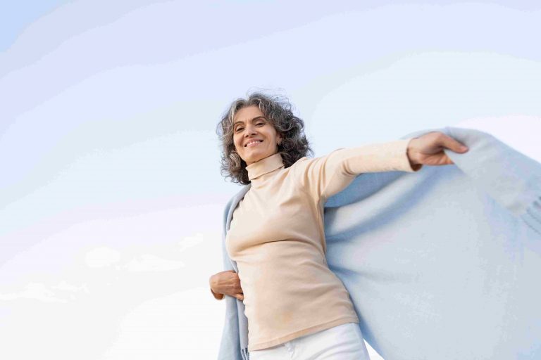 Older woman going through climacteric period having fun at beach