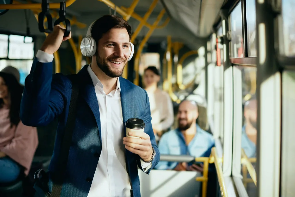 man listening to music over head phones and feeling positive while commuting by bus