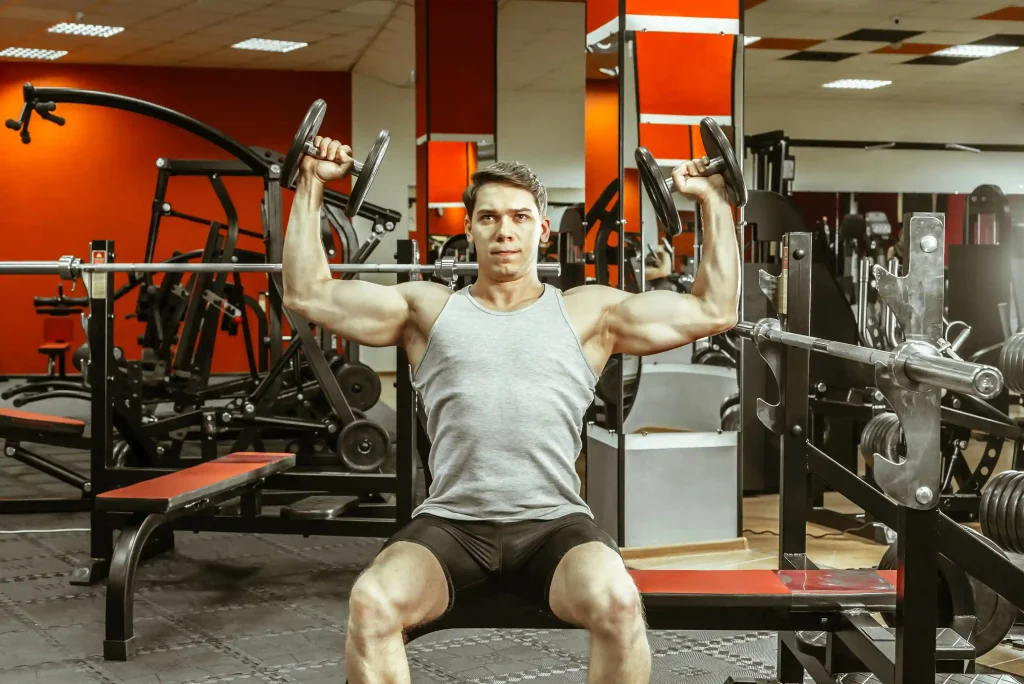 man doing military press with dumbbell at gym for core strength