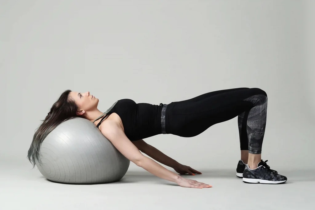 woman doing bridge exercise on a stability ball